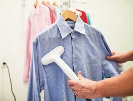 Steaming a button-up shirt with a hand steamer NDIS employment support example