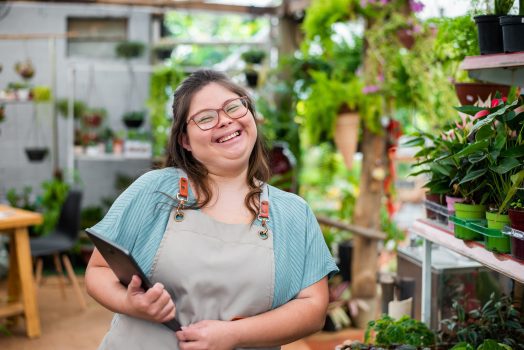 Woman with down syndrome working in small business using digital tablet