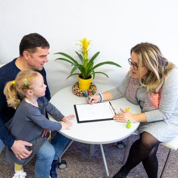 Father and toddler daughter in occupational therapist office during counselling assessment meeting.